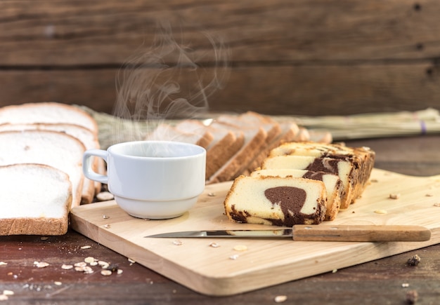 Hot coffee with cake and bread on wooden table