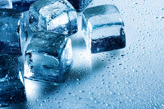 Ice cube and water drops on the wet background