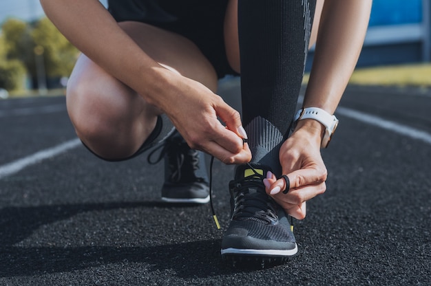 Image of lacing athletic shoes on a stadium track. Running concept.