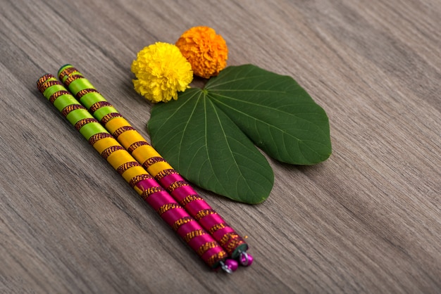 Indian Festival Dussehra and Navratriand marigold flowers with Dandiya sticks on a wooden background