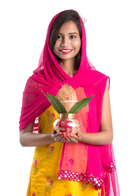 Indian girl holding a traditional copper Kalash, Indian Festival, copper Kalash with coconut and mango leaf with floral decoration, essential in Hindu Pooja.