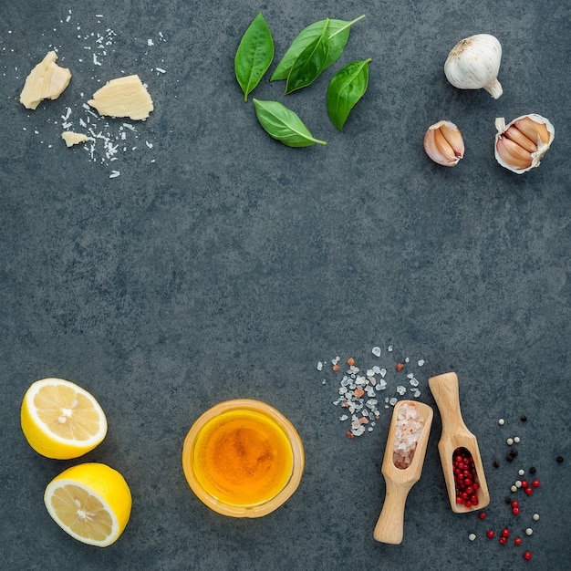 Photo the ingredients for homemade pesto sauce  on dark stone background .