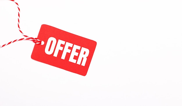 The inscription OFFER on a red price tag on a light background. Advertising concept. Copy space