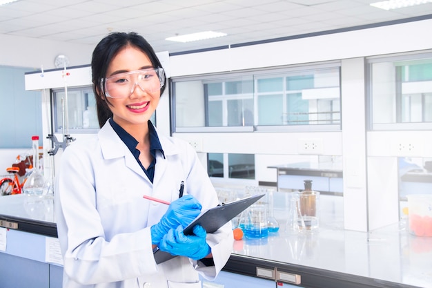 Photo interior of clean modern medical or chemistry laboratory. laboratory scientist working at a lab. laboratory concept with asian woman chemist.