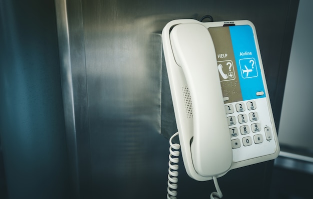 Internal phone hanging on a pole in the international airport for assistance and help.