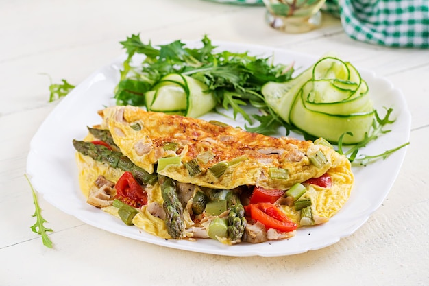 Keto breakfast Omelette with chicken fillet tomatoes and asparagus on white wooden table Italian frittata Keto ketogenic lunch