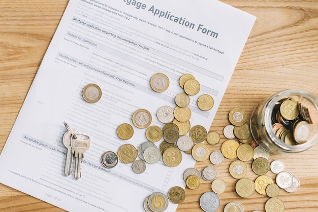 Keys and coins on mortgage application form