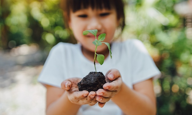 Photo kid planting a tree for help to prevent global warming or climate change