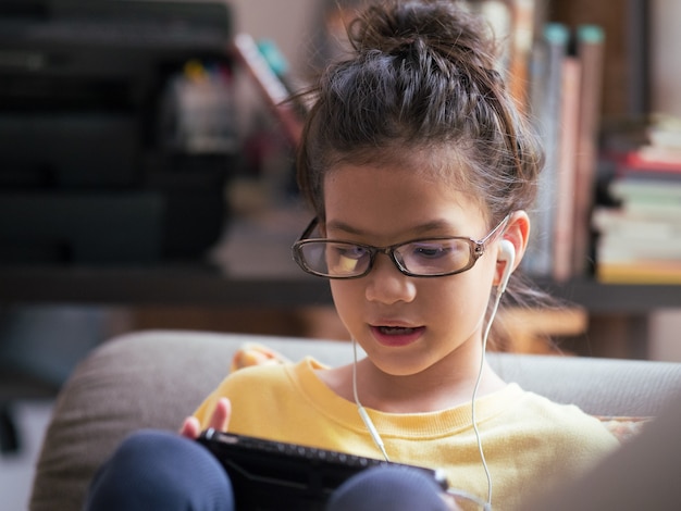 kid wearing eyeglasses using internet devicess concept of internet of things and nerd culture 