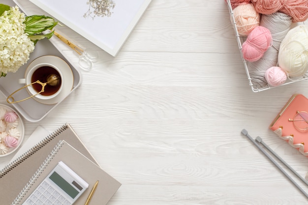 Photo knitting tools with tea on a wooden floor