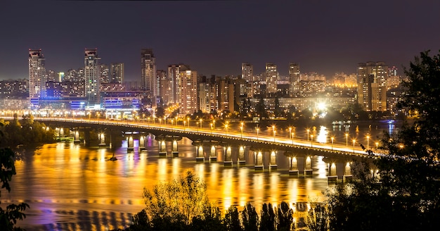 Kyiv (Kiev) city, the capital of Ukraine at night beside the Dnipro (Dniepr) river with reflection in water