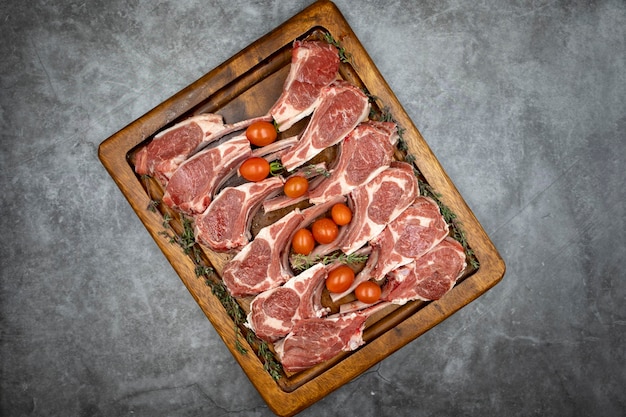 Lamb chops on dark background Raw lamb chops on wood serving board Top view