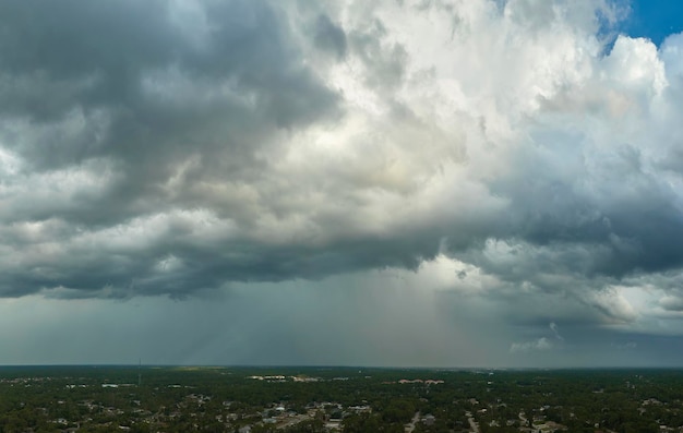 Landscape of dark ominous clouds forming on stormy sky before heavy thunderstorm over rural town area