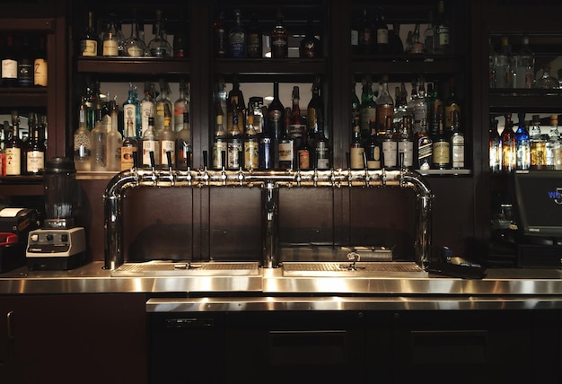 Photo liquor bottles arranged on bar shelves