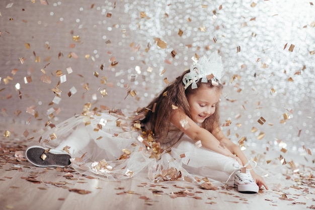 Little child girl in princess dress on confetti background