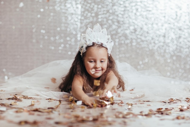 Little child girl in princess dress on confetti background