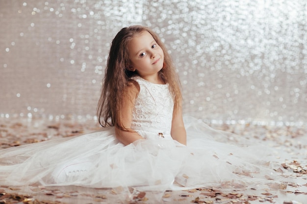 Little child girl in princess dress on confetti background