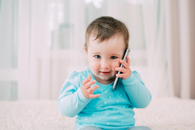 A little girl talking on a smartphone smiling and happy very sweet