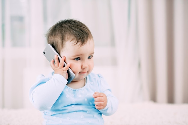 A little girl talking on a smartphone smiling and happy very sweet