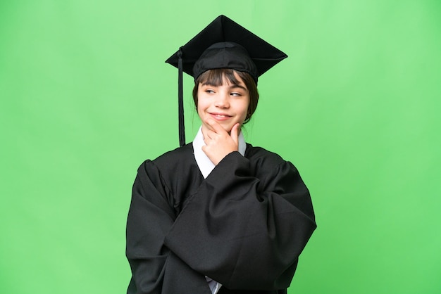 Photo little university girl over isolated background looking to the side