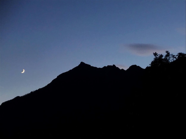 Photo 해가 지는 하늘을 배경으로 산의 실루을 낮은 각도로 볼 수 있다.