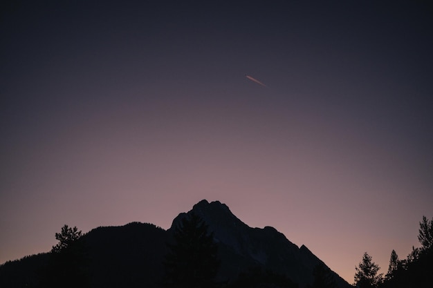 Photo 해가 지는 하늘을 배경으로 산의 실루을 낮은 각도로 볼 수 있다.