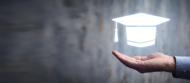 Foto uomo che tiene il simbolo del cappuccio di graduazione istruzione