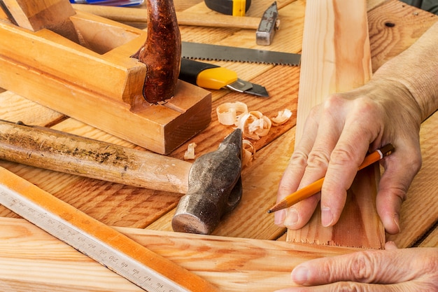 Photo man's hand working on carpenter's desk and working tools