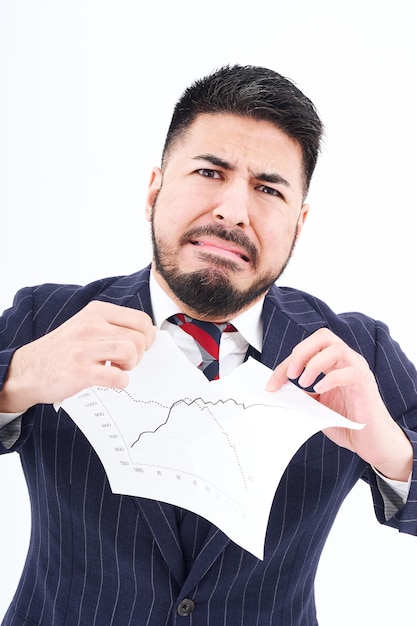 A man in a suit tearing up materials