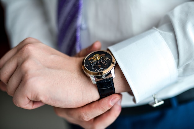 Man in a tux fixing his cufflink