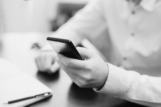 Man using smartphone, bw photo