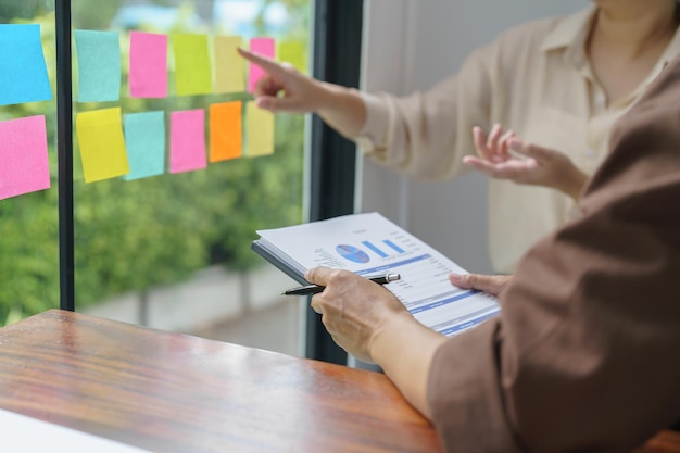 Foto mensen uit het bedrijfsleven die aan plaknotities werken, creatief ideeën opschrijven op post-it-notities, professionele investeerders starten projectactiviteiten