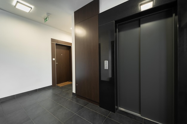 Photo modern apartment building elevator lobby with dark wood panels