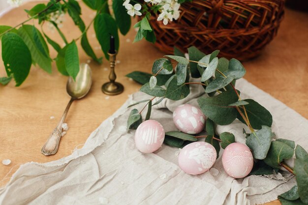 Photo modern easter eggs with eucalyptus branch on rustic wooden table stylish pastel pink easter eggs with floral ornaments painted in natural dye from beets happy easter greeting card