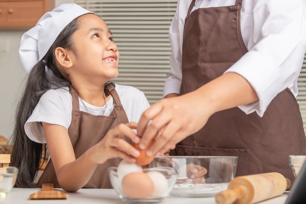 Mother and daughter are helping to collect eggs in clear cup