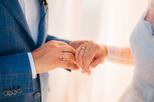 Photo the newlyweds exchange rings at a wedding