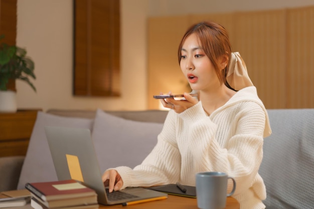 Photo nightlife concept young woman talking on smartphone and typing on laptop in late night winter