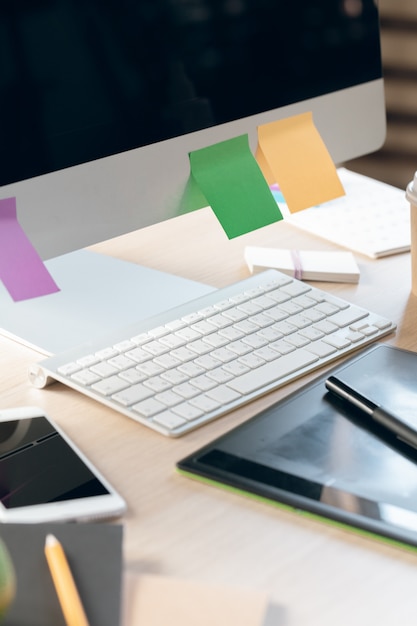 Office table with smartphone and supplies close up, office interior