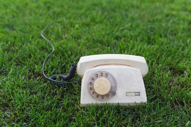 Old retro phone on the green grass