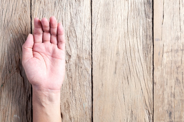 Open asia male hand on wooden background.