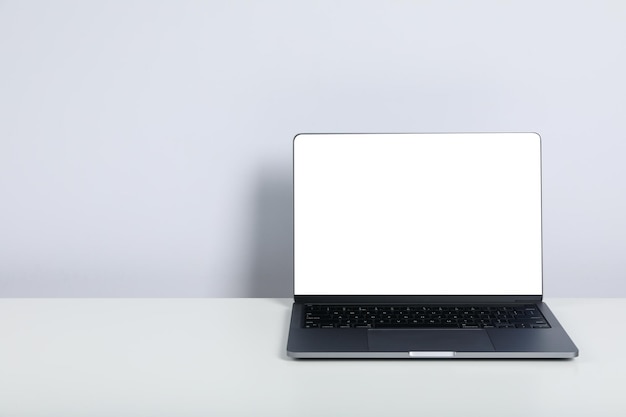 Open laptop with blank screen on white table