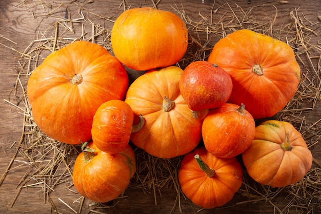 Orange pumpkins on wooden table. Autumn harvest background, top view