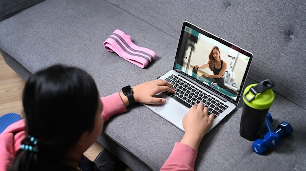 Photo overweight young woman watching online training on laptop computer at home.