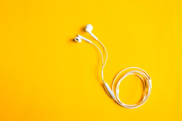 a pair of earphones are on a yellow background