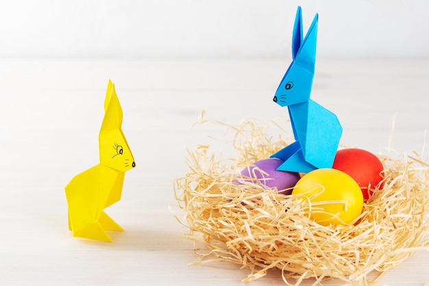 Paper bunnies with Easter eggs and a nest on the table