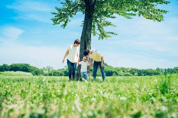 Photo parents and their child lined up under a tree