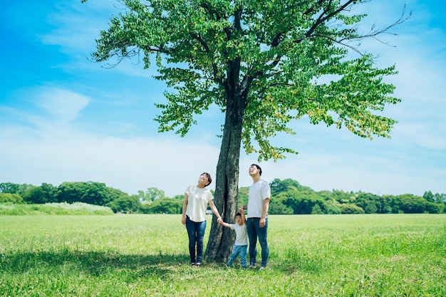 Parents and their child lined up under a tree