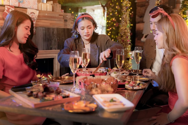 Photo party of beautiful asian friend female and male celebrating woman serving pizza on table