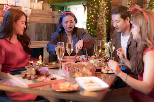 Photo party of beautiful asian friend female and male celebrating woman serving pizza on table