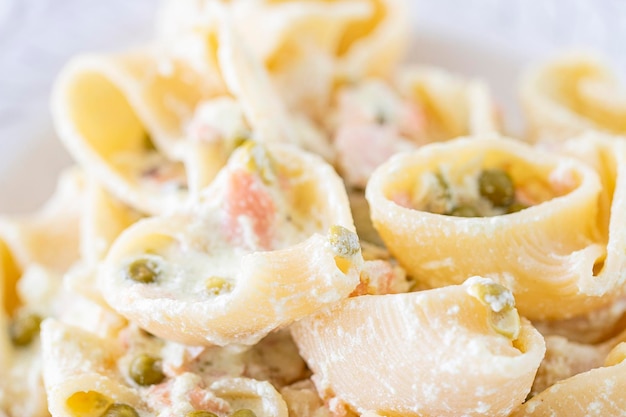 Photo pasta lumaconi with peas smoked salmon and cream